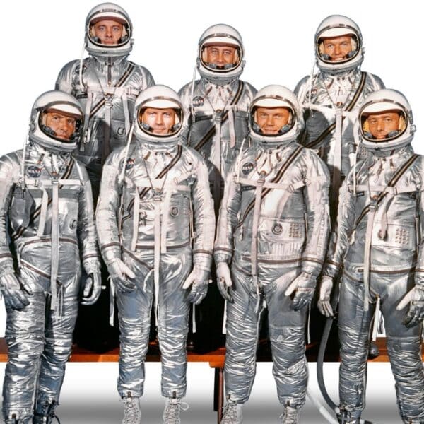 The seven original Mercury astronauts wearing silver space suits