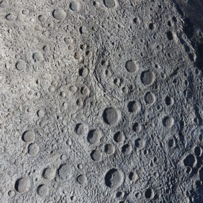 Heavily cratered surface of the Moon with numerous impact marks