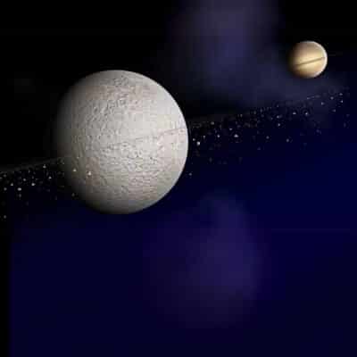 Large cratered moon with debris ring orbiting near Saturn in space