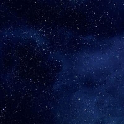 Star-filled night sky with clusters of glowing stars and deep blue clouds