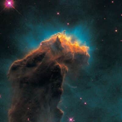 Dark pillar of gas and dust in a glowing nebula with scattered stars