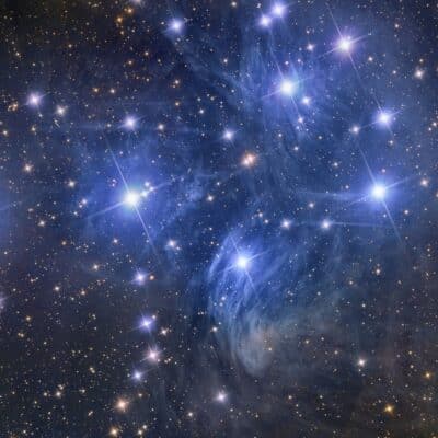 Bright stars of the Pleiades cluster surrounded by blue nebulosity
