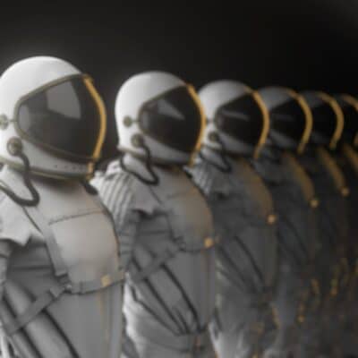 Six astronauts lined up in white spacesuits with helmets and visors