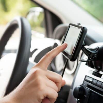 Person using a GPS navigation device inside a car