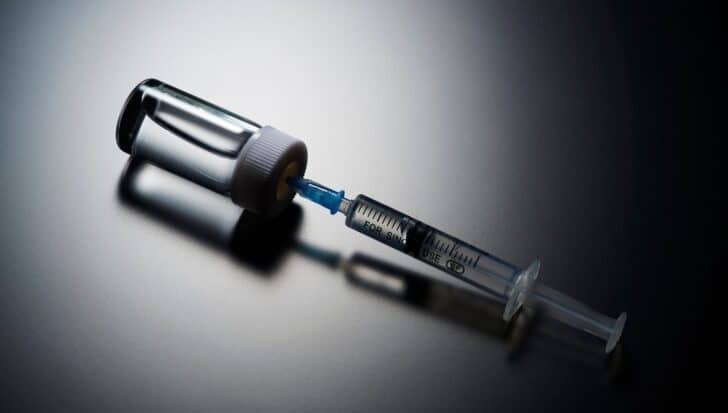 A syringe filled with liquid is attached to a vial, relevant to the CIA's use of a fake vaccine program for espionage purposes