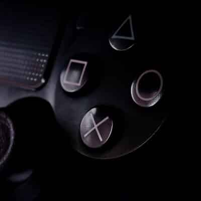 Close-up of PlayStation controller buttons in dim lighting