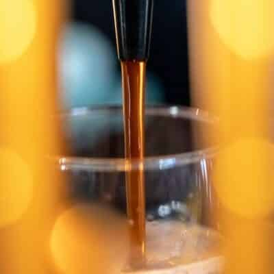 Coffee pouring from a machine into a glass cup