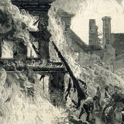 Firefighters battle intense flames engulfing a building as people shovel debris