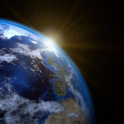 Earth from space with sunlight illuminating the planet’s surface and atmosphere