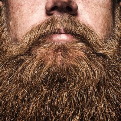 Close-up of a man's thick, reddish-brown beard and mustache