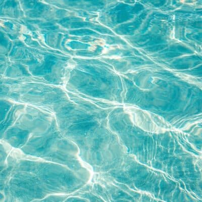 Sunlight reflecting on the surface of clear blue water