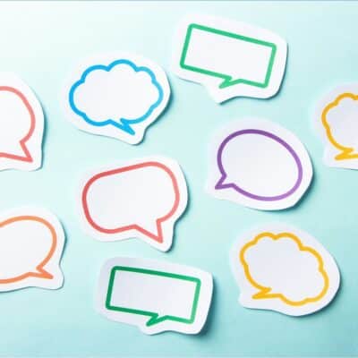 Colorful speech and thought bubble cutouts scattered on a light blue background