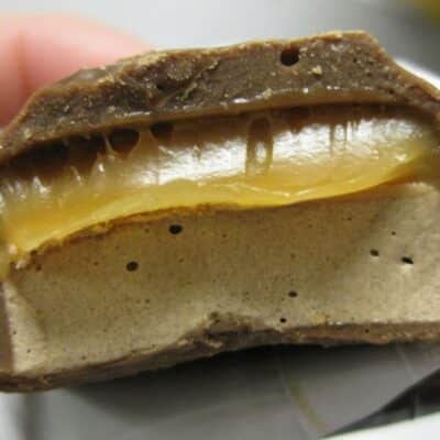 Cross-section of a chocolate bar with caramel and nougat layers