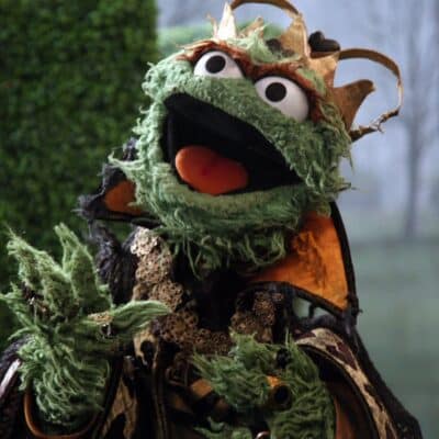 Oscar the Grouch wearing a tattered royal costume and a gold crown