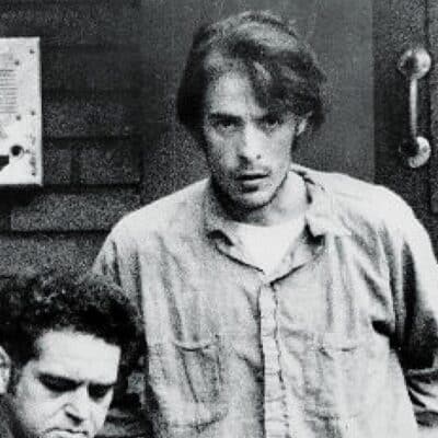 Richard Chase being escorted by a detective in handcuffs