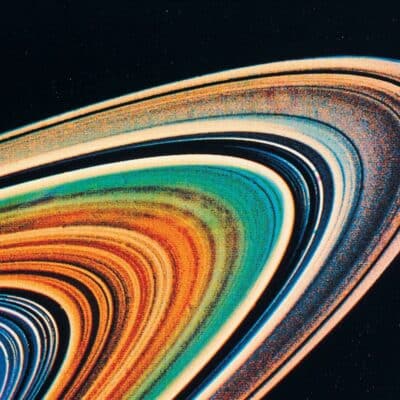 Color-enhanced close-up of Saturn’s thin, multi-colored rings against a dark space background
