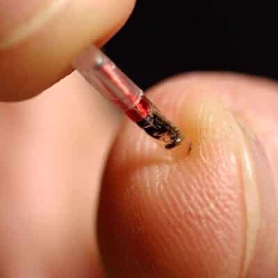 Close-up of a person holding a microchip near their fingertip