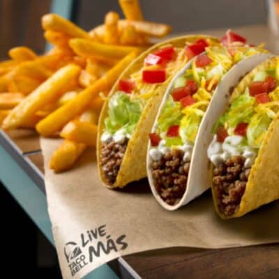 Taco Bell tacos with seasoned beef, lettuce, cheese, tomatoes, and a side of fries