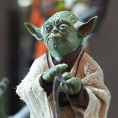 Close-up of a Yoda figure in Jedi robes with hand raised