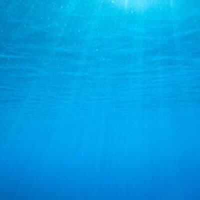 Sunlight filtering through clear, deep blue ocean water