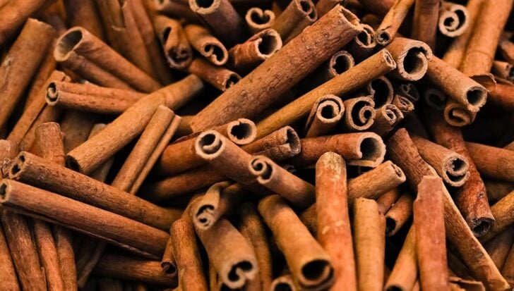 A close-up of numerous cinnamon sticks, highlighting the spice's prominence in pumpkin spice blends