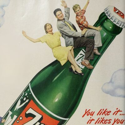 Vintage ad with a smiling family riding a giant 7-Up bottle