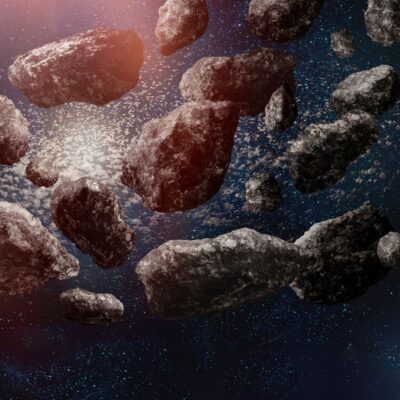 Densely packed asteroids floating in space against a starry backdrop