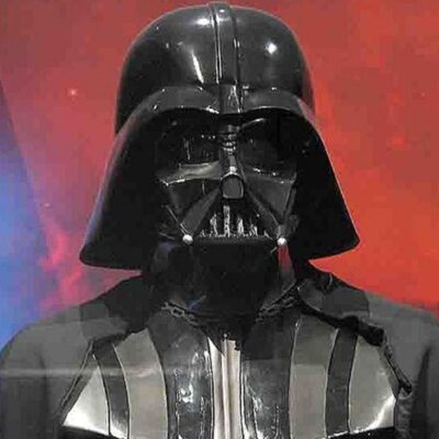 Darth Vader costume with black helmet and chest armor against red background