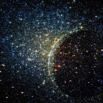 Dense field of colorful stars with a curved glow resembling cosmic radiation