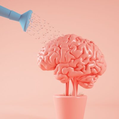 Watering can pouring water onto a brain growing from a flowerpot
