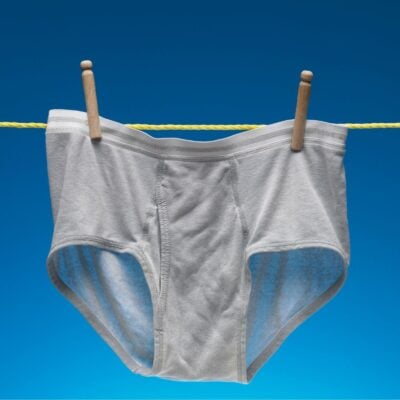 Gray men's underpants hanging on a clothesline with clothespins