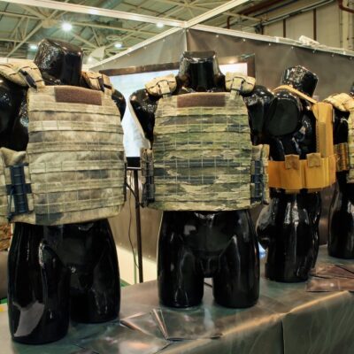 Modern bulletproof vests displayed on black mannequins at an exhibition booth