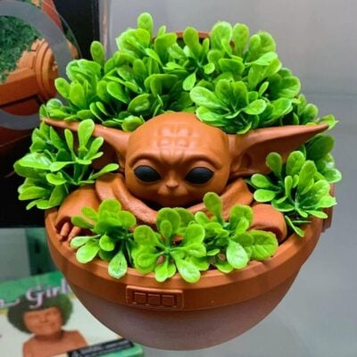 Chia Pet modeled after Baby Yoda with green sprouts growing from it