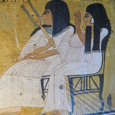 Ancient Egyptian wall painting of two seated figures with dark wigs and white robes