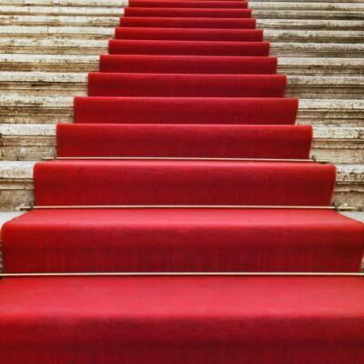 Red carpeted staircase leading up marble steps