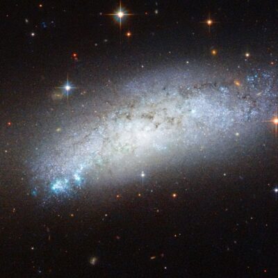 Bright spiral galaxy surrounded by stars and cosmic dust in space