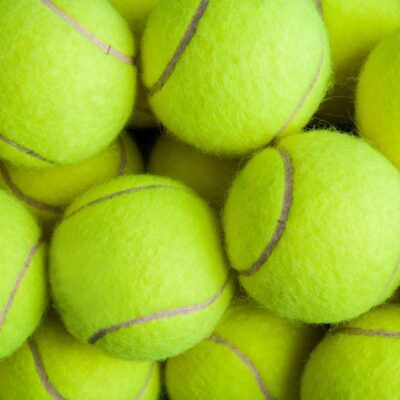 Close-up of a pile of bright yellow tennis balls