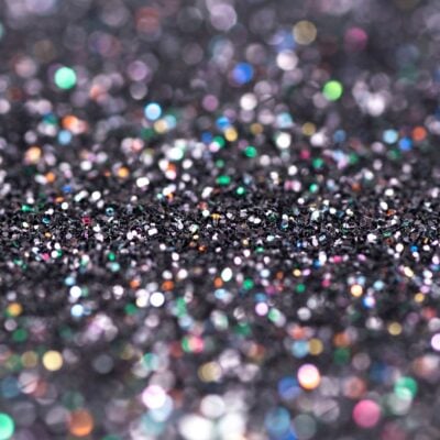 Colorful microplastic glitter scattered on a dark surface