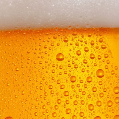Close-up of a cold beer with bubbles and foamy head