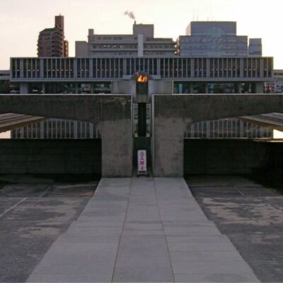 Peace Flame burning at Hiroshima Peace Memorial Park with museum in background