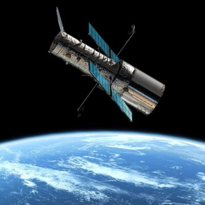 Hubble Space Telescope orbiting above Earth with solar panels extended