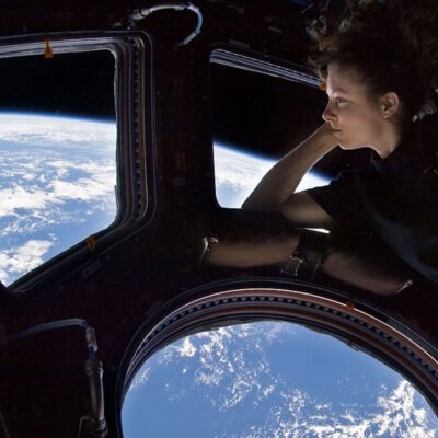 Astronaut gazes at Earth through a window on the International Space Station