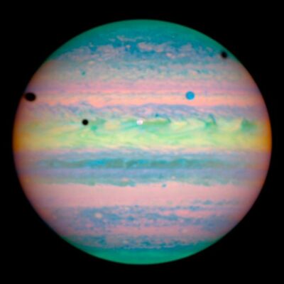 Color-enhanced view of Jupiter with several of its moons casting shadows