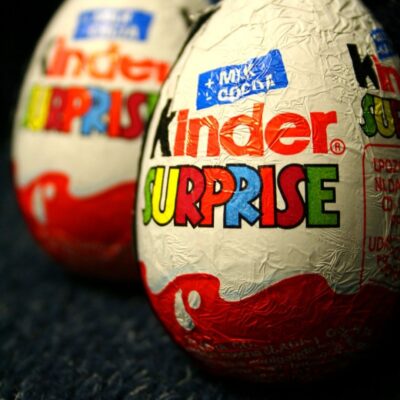 Close-up of two Kinder Surprise chocolate eggs with colorful foil wrappers