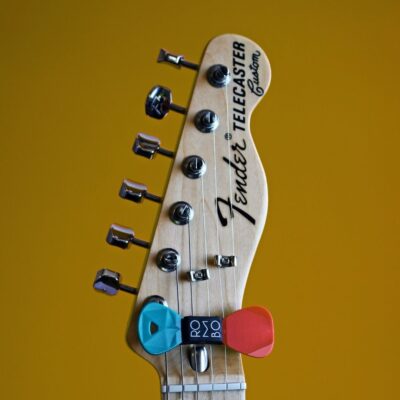 Fender Telecaster guitar headstock with two colorful picks attached