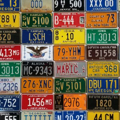 Colorful vintage license plates from various U.S. states and countries arranged in a grid