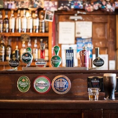 Beer taps for Guinness, Carlsberg, Heineken, Budweiser, and Harp at a pub bar