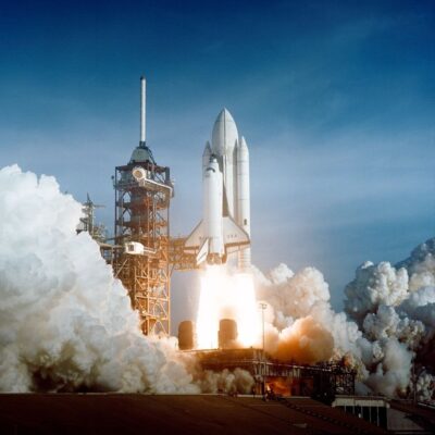 NASA space shuttle launching from Kennedy Space Center with smoke and flames below