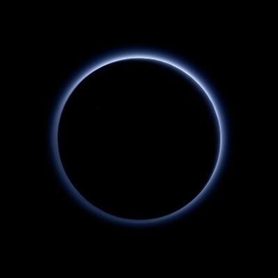 Pluto's faint blue atmospheric haze against the blackness of space