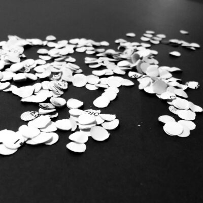 Scattered chad pieces on a dark surface